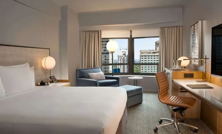 King room with work desk and sofa at New York Hilton Midtown.