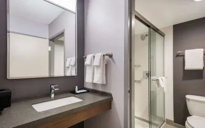 Private guest bathroom with shower and free toiletries at Sonesta Select San Jose Airport.