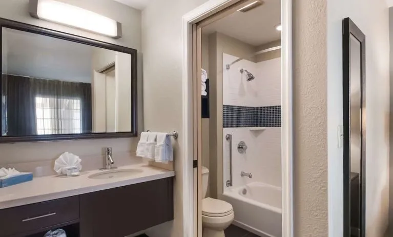 Private guest bathroom with combined shower and tub at Sonesta ES Suites Dulles Airport.