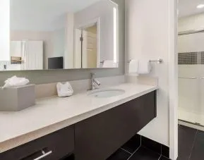 Private guest bathroom with shower and free toiletries at Sonesta ES Suites Dulles Airport.
