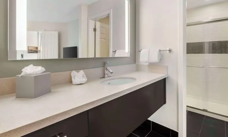 Private guest bathroom with shower and free toiletries at Sonesta ES Suites Dulles Airport.