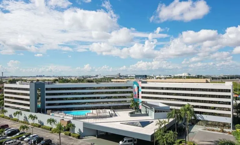 Exterior view of Sonesta Miami Airport and parking area. 