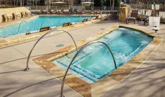 Refreshing outdoor pool and hot tub at Hilton Dallas/ Plano Granite Park.