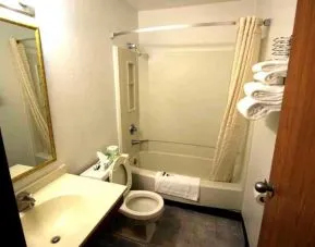 Private guest bathroom with combined shower and tub at Norwood Inn Minneapolis Roseville.
