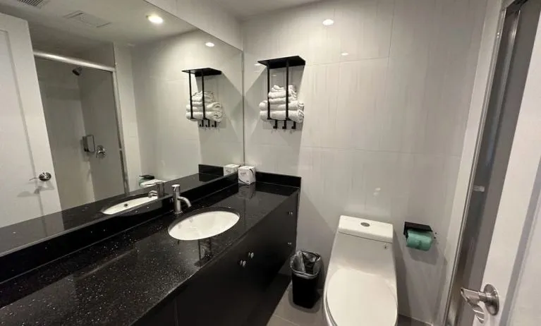 Private guest bathroom with shower and free toiletries at Regal Inn & Suites New York.