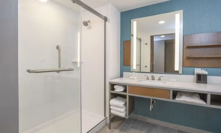 Private guest bathroom with shower and free toiletries at Hilton Garden Inn Cincinnati Midtown.