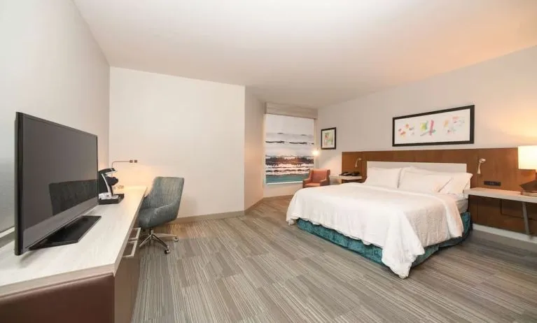 Spacious day use room with king bed, workdesk, TV screen and private bathroom at Hilton Garden Inn Cincinnati Midtown.