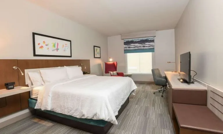 Bright and spacious day use room with king bed, work desk and TV screen at Hilton Garden Inn Cincinnati Midtown.