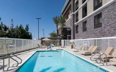 Outdoor pool with lounge chairs at Hampton Inn Los Angeles-Orange County-Cypress.