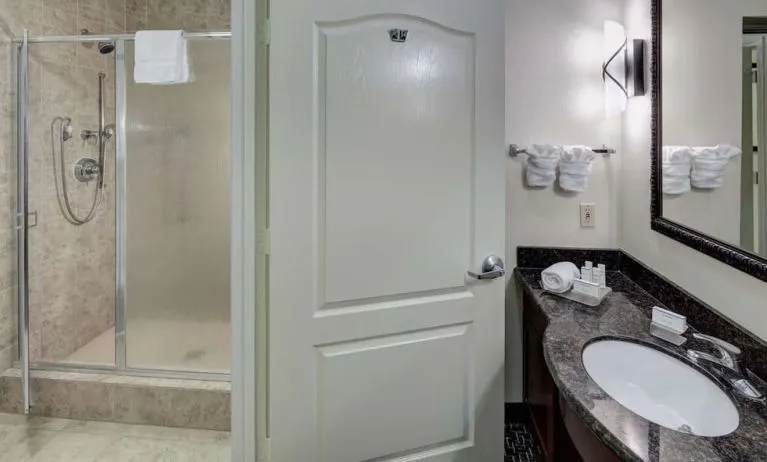Private guest bathroom with shower and free toiletries at Homewood Suites By Hilton Agoura Hills.