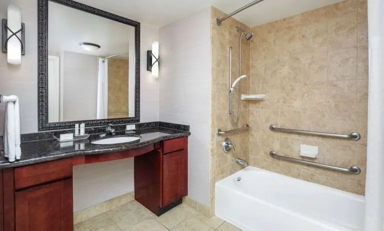 Private guest bathroom with combined shower and tub at Homewood Suites By Hilton Agoura Hills.