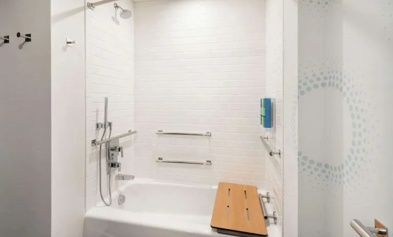 Private guest bathroom with combined shower and tub at Tru By Hilton Denver Downtown Convention Center.