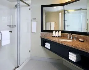 Private guest bathroom with shower and free toiletries at Embassy Suites By Hilton Los Angeles-Intl Airport North.