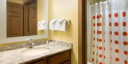 Private guest bathroom with shower and free toiletries at Sonesta Simply Suites Phoenix Scottsdale.