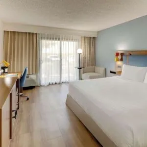 Day use room with king bed, work desk, sofa, TV screen and floor to ceiling window at Sonesta Select Scottsdale At Mayo Clinic Campus.
