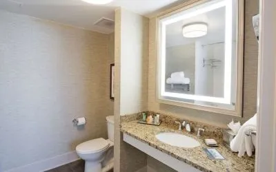 Private guest bathroom with shower and free toiletries at Hilton Baton Rouge Capitol Center.