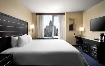 Delux king room with TV and work desk at Hilton New York Fashion District.