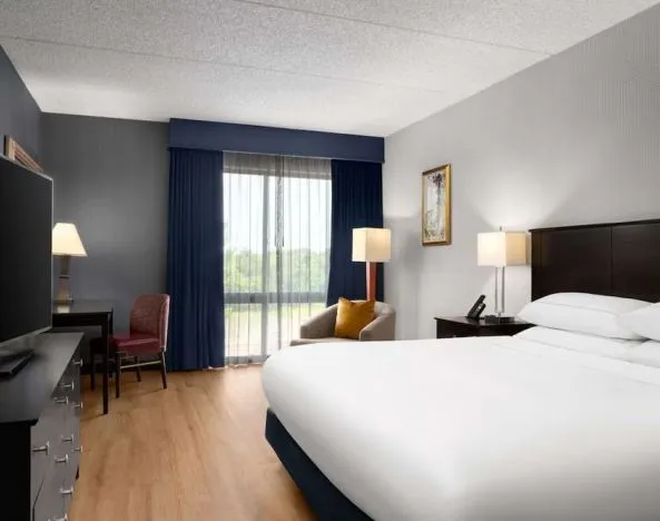 Day use room with floor to ceiling window, work desk, king bed and private bathroom at DoubleTree By Hilton Hartford - Bradley Airport.