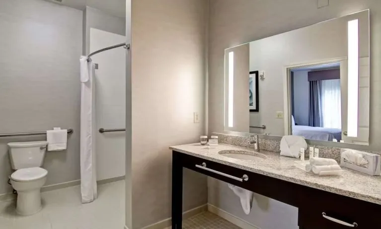 Private guest bathroom with shower and free toiletries at Homewood Suites By Hilton Newark-Cranford.