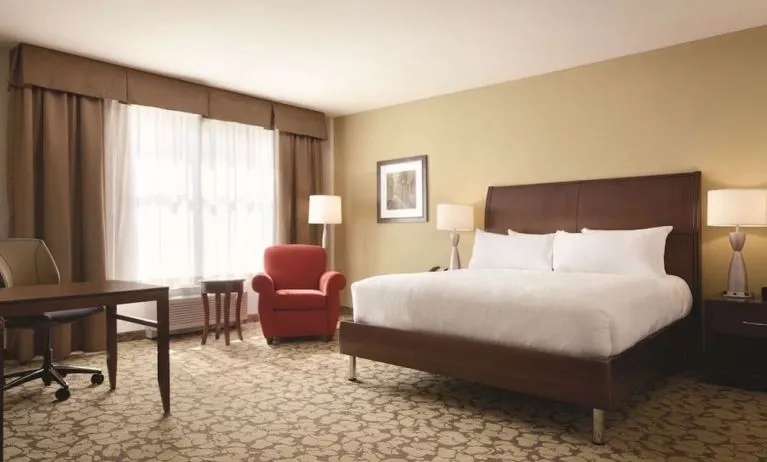 Spacious delux king bed with TV and work desk at Hilton Garden Inn Boston Logan Airport.