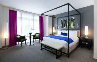 King bedroom with seating area and natural light at Royalton Park Avenue.