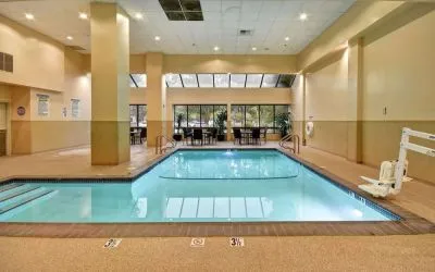 Relaxing indoor pool with seating area at Embassy Suites By Hilton Santa Clara Silicon Valley.