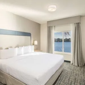King bed with TV and a view of the Blue Lagoon at Homewood Suites By Hilton Miami Airport-Blue Lagoon.
