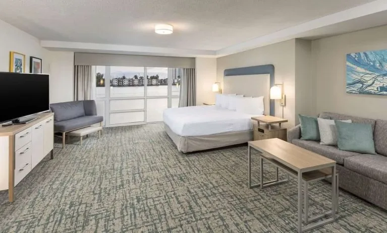 Spacious day use room with sofa and a view of the Blue Lagoon at Homewood Suites By Hilton Miami Airport-Blue Lagoon.