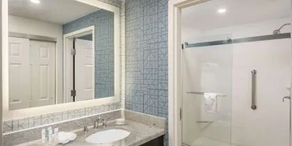 Guest bathroom with shower at Homewood Suites By Hilton Miami Airport-Blue Lagoon.