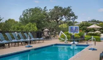 One of the 3 outdoor pools with loungers at Hilton San Antonio Hill Country.