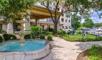 Hotel facade and the parking area at Hilton San Antonio Hill Country.