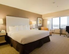 Delux king room with work desk and natural light at Hilton Los Angeles Airport.