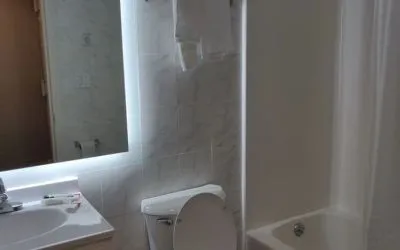 Guest bathroom with shower and tub at Hotel Key.