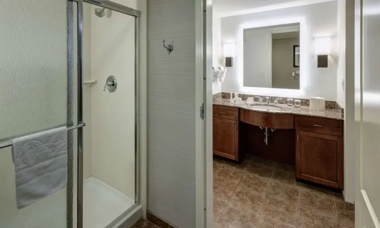 Private guest bathroom with shower and free toiletries at Homewood Suites By Hilton Denton.