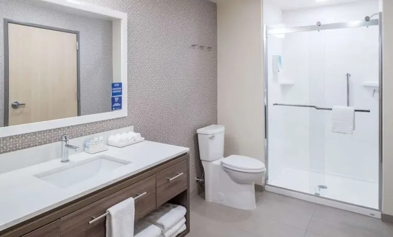 Private guest bathroom with shower and free toiletries at Home2 Suites By Hilton Cape Canaveral Cruise Port.