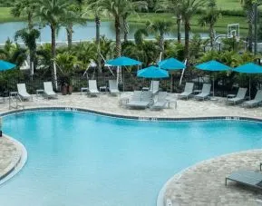 Outdoor pool with lounge seating at Home2 Suites By Hilton Cape Canaveral Cruise Port.