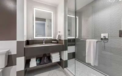 Private guest bathroom with shower and free toiletries at The Rose Hotel Chicago O’Hare, Tapestry Collection By Hilton.