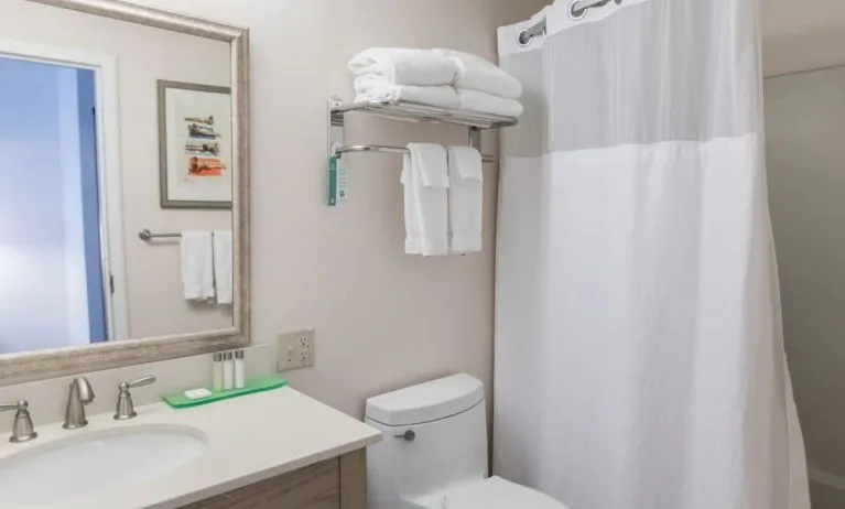 Private guest bathroom with shower and free toiletries at Sea Crest Beach Hotel.
