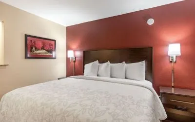 King bed at Red Roof PLUS+ & Suites Houston - IAH Airport SW.