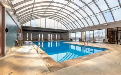 Relaxing indoor pool with lounge chairs at Wyndham Omaha.