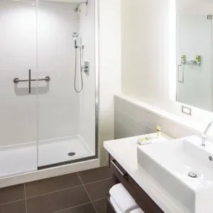Private guest bathroom with shower and free toiletries at Element Miami International Airport.