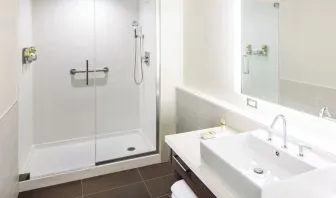 Private guest bathroom with shower and free toiletries at Element Miami International Airport.