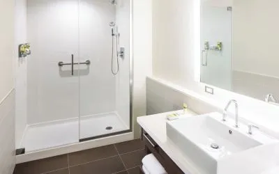 Private guest bathroom with shower and free toiletries at Element Miami International Airport.