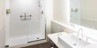 Private guest bathroom with shower and free toiletries at Element Miami International Airport.