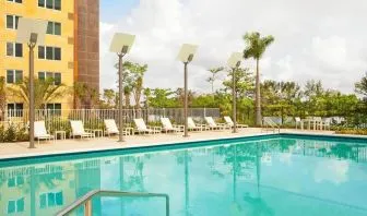 Outdoor pool with lounge chairs at Element Miami International Airport.