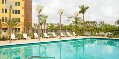 Outdoor pool with lounge chairs at Element Miami International Airport.