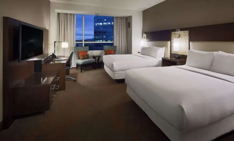 Day use twin room with workspace and lounge seating at Hilton Dallas/ Plano Granite Park.