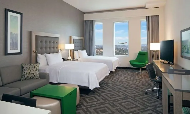 Twin bedroom with work desk and sofa at Homewood Suites By Hilton LAX Airport.