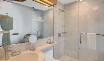 Private guest bathroom with shower and free toiletries at Wyndham Garden Brooklyn Sunset Park.