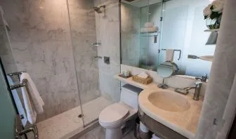 Private guest bathroom with shower and free toiletries at Wyndham Garden Brooklyn Sunset Park.